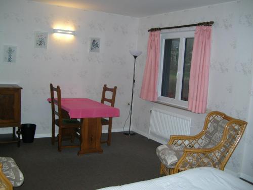 a room with a pink table and chairs and a bed at Auberge Le Vieux Moulin in Poupehan