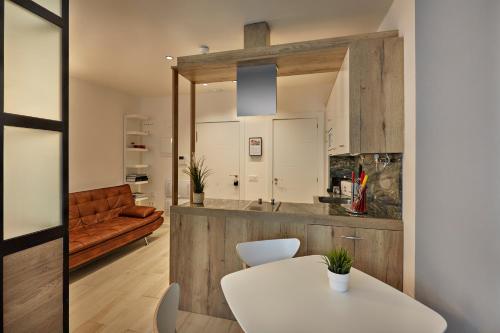 a kitchen with a white table and a couch at Apartamentos Abastos in Logroño