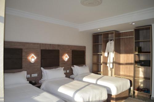 pokój hotelowy z 2 łóżkami i półkami w obiekcie AGREMAS w mieście Mascara