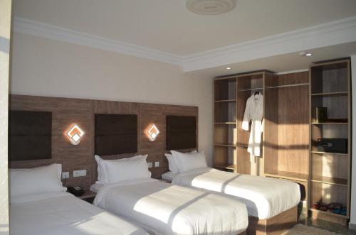 pokój hotelowy z 2 łóżkami i półkami w obiekcie Hôtel AGREMAS w mieście Mascara