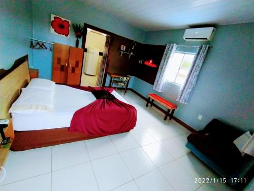 a bedroom with a bed with a red dress on it at Casal.20 Studios Flats in Cabo de Santo Agostinho