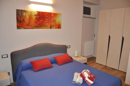 ein Schlafzimmer mit einem blauen Bett mit zwei roten Kissen in der Unterkunft Sotto la torre in Costigliole dʼAsti