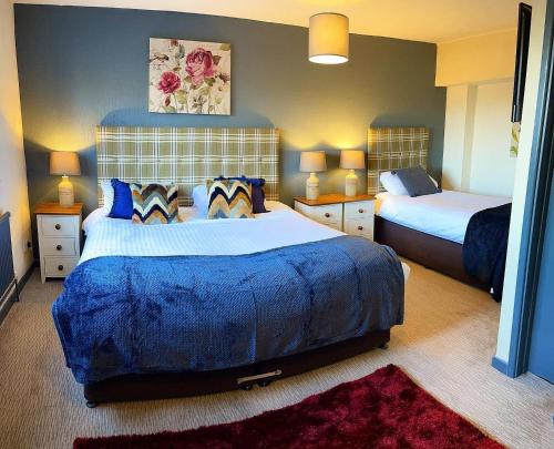 a bedroom with two beds and two lamps in it at The Coach and Horses Inn in Chepstow
