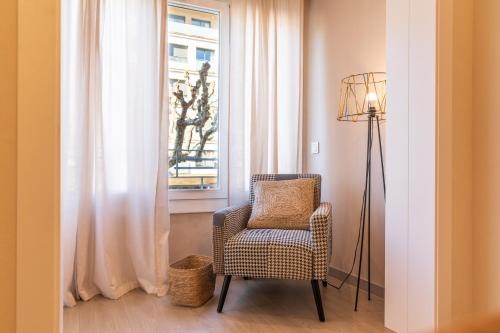 a chair and a lamp in a room with a window at Lo passeig in Tremp