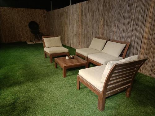 three lounge chairs and a table in a room at חאן בכפר במשק בלה מאיה - הצימר in Nevatim