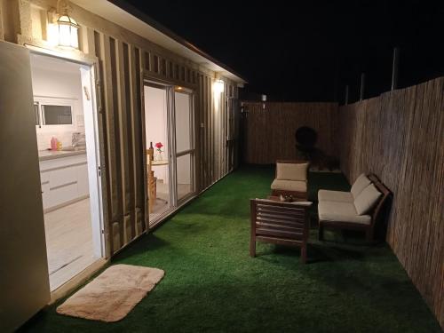 a room with a green floor and a room with a table and chairs at חאן בכפר במשק בלה מאיה - הצימר in Nevatim