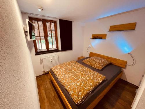 a small bedroom with a bed and a window at AlpLodge in Pfronten