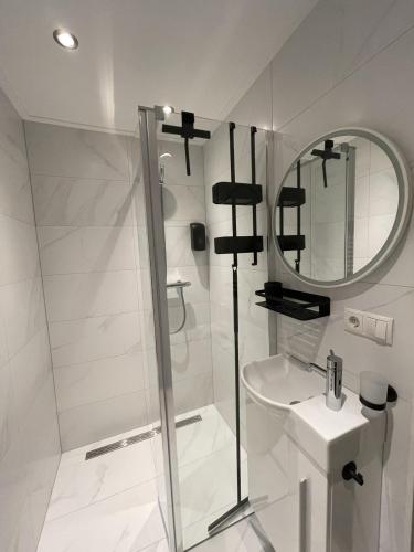 a white bathroom with a shower and a sink at Landgoed De Heezeberg in Diever