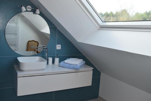 uma casa de banho com um lavatório e um espelho em Les chambres d hôtes de l entre deux baies à Merlimont entre Berck et le Touquet em Merlimont