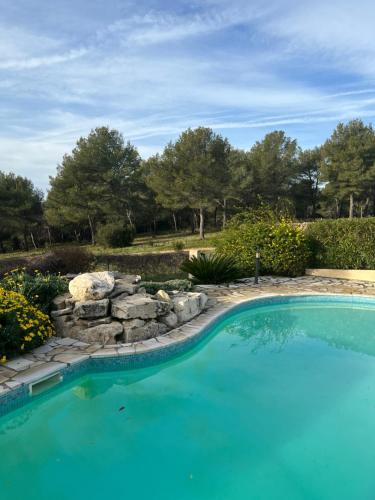- une piscine dans une cour avec un mur en pierre et des arbres dans l'établissement Au Petit Paradis, à Roquefort-la-Bédoule