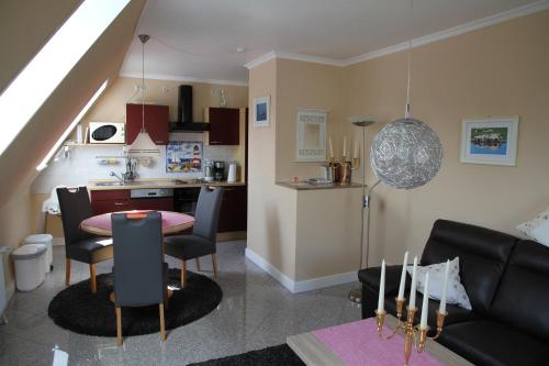 a living room with a table and a kitchen at Haus Wattenmeer in Tönning