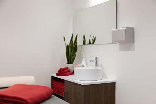 ein Badezimmer mit einem Waschbecken und einem roten Stuhl in der Unterkunft Sporthotel TREFF PUNKT in Wiesbaden