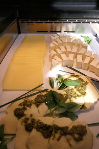 a tray of cheese and other foods in an oven at Sporthotel TREFF PUNKT in Wiesbaden