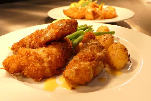 a plate of food with chicken nuggets and green beans at Sporthotel TREFF PUNKT in Wiesbaden