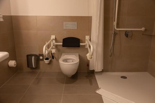 a small bathroom with a toilet and a shower at Sporthotel TREFF PUNKT in Wiesbaden