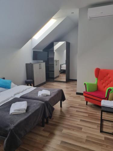 - une chambre avec deux lits et une chaise rouge dans l'établissement MŁYŃSKA 8 Opole-Górki, à Carolinensiel