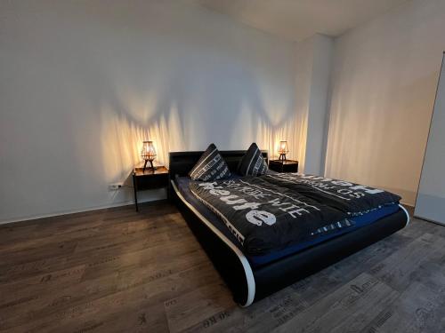 a bedroom with a bed with two lamps on the wall at Spremberger City Ferienwohnung in Spremberg