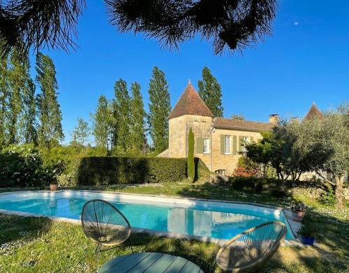 a swimming pool in front of a house at Le Tilleul in Grézillac