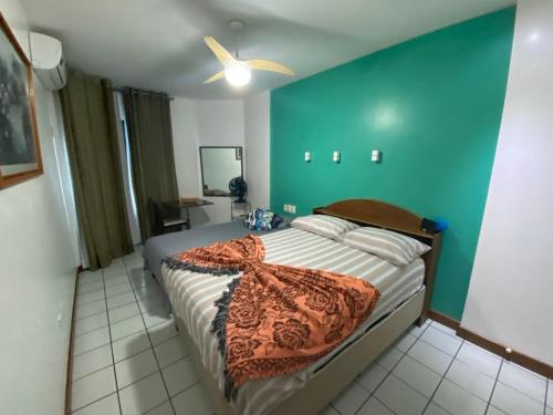 1 dormitorio con cama y pared azul en Apartamento Barra Tropical Residence, en Salvador