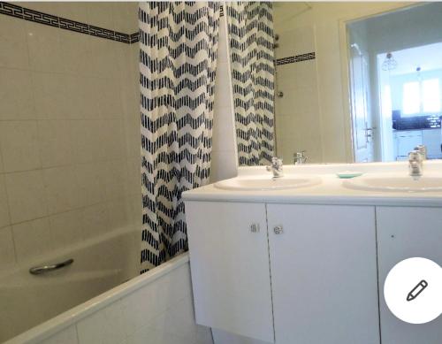 une salle de bain avec un lavabo et un rideau de douche dans l'établissement Disneyland Paris Apartment balcon & parking 344, à Serris
