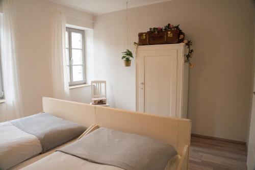 a bedroom with a bed and a suitcase on the wall at Urlaubsfreude Biedermann Haus Blumenglück - Rose in Sebnitz