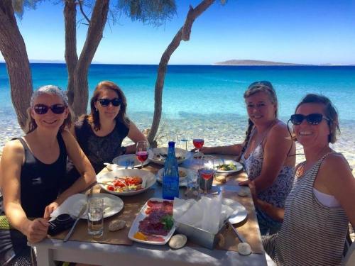 a group of women eating at a table on the beach at Aliki Panorama Rooms -breakfast included- in Aliki