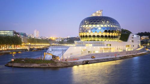 een groot gebouw met een koepel aan de kant van een rivier bij Anna's Home Sweet Home in Boulogne-Billancourt