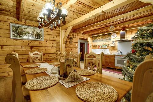a wooden dining room with a table and a christmas tree at Chata Litwor in Bukowina Tatrzańska