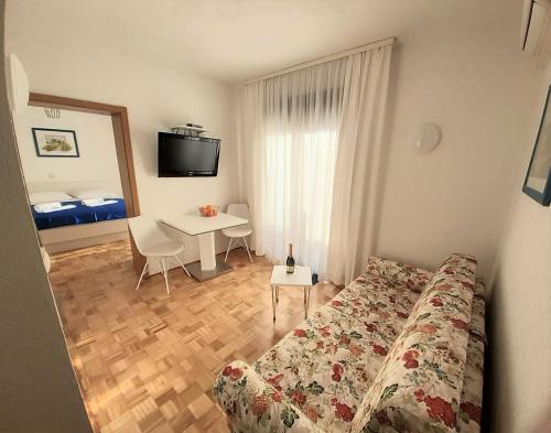 a bedroom with a bed and a table with a desk at Pension Alba in Podstrana
