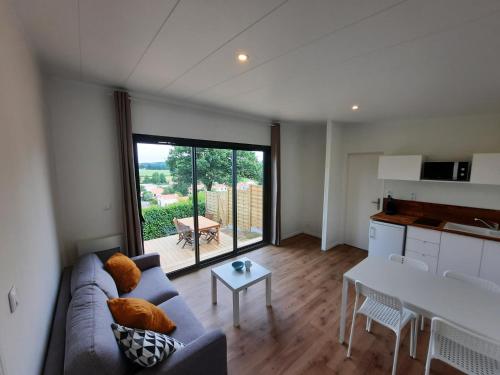 un salon avec un canapé et une table dans l'établissement Le cottage castelmurois, à Châteaumur