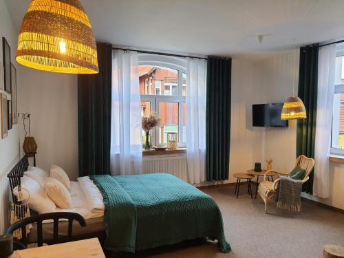 a bedroom with a bed with a green blanket at Apartamenty Deptak - w centrum Karpacza, parking w cenie! in Karpacz