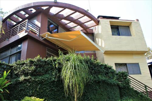 a house with an umbrella hanging off the side of it at Karjat Villa (3 BHK) With Garden Amidst Nature in Karjat