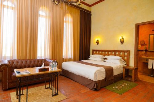 une chambre d'hôtel avec un lit et un canapé dans l'établissement Caucasus Hotel, à Erevan