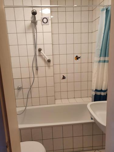 een badkamer met een douche, een toilet en een wastafel bij Ferienwohnung Linden in Willich