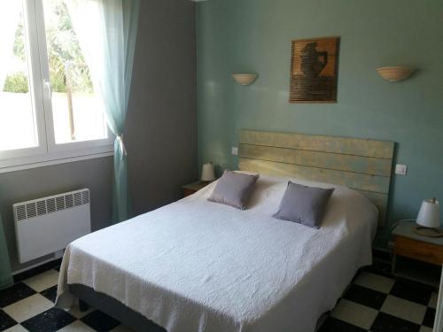 a bedroom with a large white bed with a window at la luciole 2 in Canet-en-Roussillon