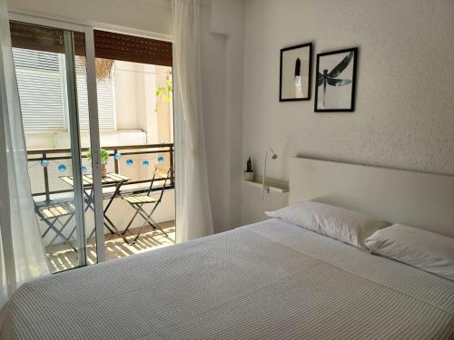 a bedroom with a bed and a view of a balcony at Apartament Ampolla Port in L'Ampolla