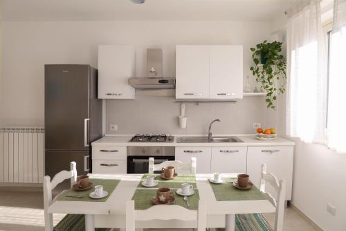 een keuken met een tafel en een keuken met witte kasten bij La Perla in Taormina