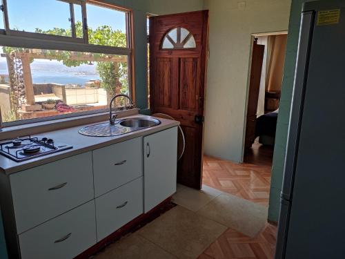 cocina con fregadero y ventana en Hospedaje Maria Teresa, en Valparaíso
