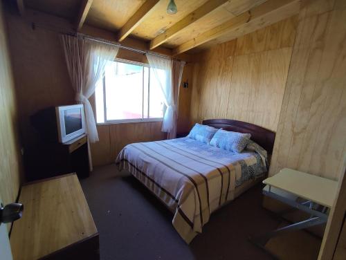 Dormitorio pequeño con cama y TV en Hospedaje Maria Teresa, en Valparaíso