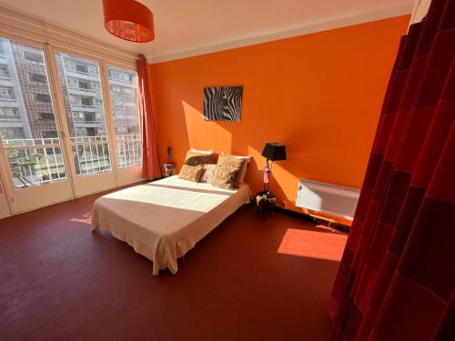 - une chambre avec des murs orange et un lit dans l'établissement Le Gambetta, à Toulon
