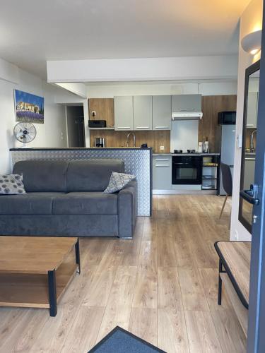 un salon avec un canapé et une cuisine dans l'établissement Ruby, à La Rochelle