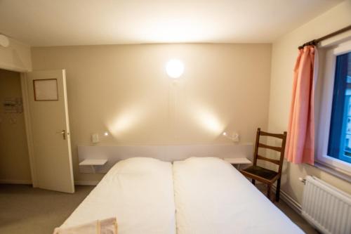 a bedroom with a bed and a light on the wall at Auberge Le Vieux Moulin in Poupehan