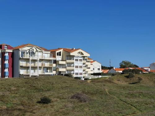 a large apartment building on top of a hill at T2 cozy face dunes et océan - Thalasso et golf in Saint-Jean-de-Monts