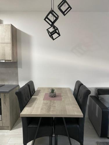 ein Esszimmer mit einem Tisch und schwarzen Stühlen in der Unterkunft Apartman Petra in Jagodina