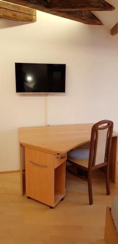 a wooden desk with a television on a wall at Villa Hoffnung in Bad Elster