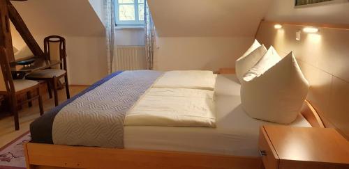 a bedroom with a bed with white sheets and pillows at Villa Hoffnung in Bad Elster