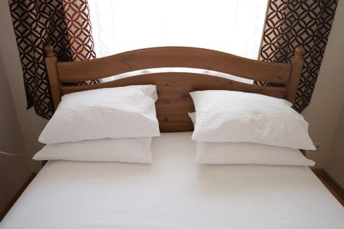 1 cama con almohadas blancas y ventana en Cosy and Comfortable Apartment in Cracov, en Cracovia