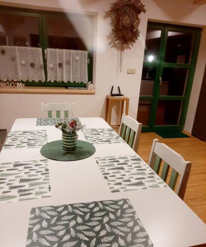 a table with a vase of flowers on top of it at Zelený Jelen - horský apartmán in Stachy