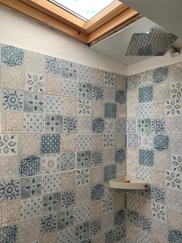 La salle de bains est revêtue de carrelage bleu et blanc. dans l'établissement Cosy Apartment with Terrace view in Sarzana Italy, à Marinella di Sarzana