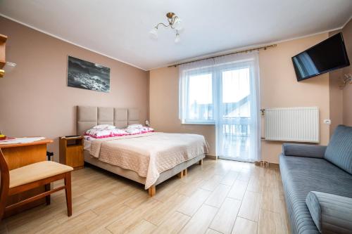 1 dormitorio con 1 cama y 1 sofá en Dom Wczasowy Grażyna, en Władysławowo